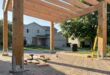 Carport aus Holz im Rohbau mit Pfosten und Dachkonstruktion